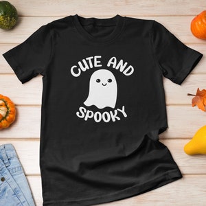 May include: Black t-shirt with a white ghost graphic and the text "Cute and Spooky".