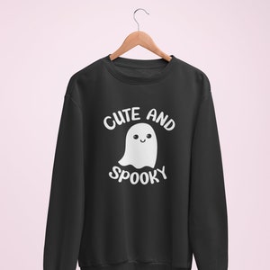 May include: Black sweatshirt with a white ghost graphic and the text "Cute and Spooky".