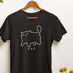 May include: Black t-shirt with a white outline of a cat and the word "cat" underneath.