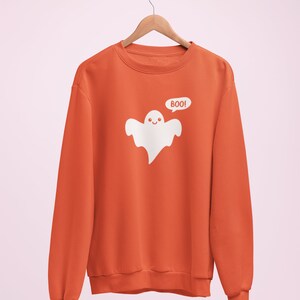 May include: Orange sweatshirt with a white ghost graphic and the text "BOO!" printed on the front.
