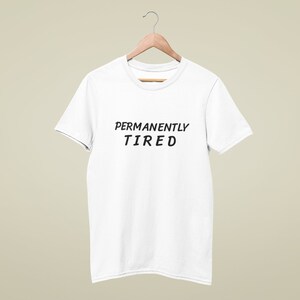 May include: White t-shirt with the text "PERMANENTLY TIRED" printed in black.