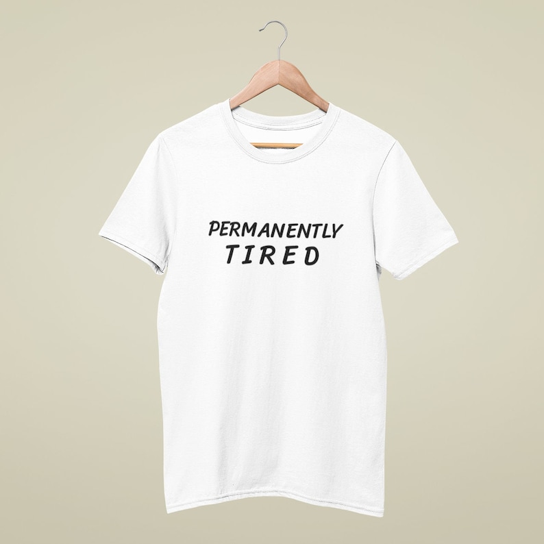 May include: White t-shirt with the text "PERMANENTLY TIRED" printed in black.