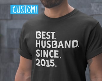 May include: Black t-shirt with white text that reads "BEST. HUSBAND. SINCE. 2015."
