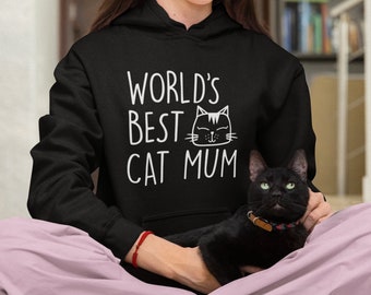 May include: A person wearing a black hoodie with the text "WORLD'S BEST CAT MUM" and a black cat sitting on their lap.