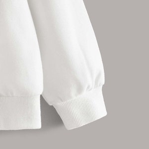 May include: White long-sleeve sweatshirt with a ribbed cuff detail.