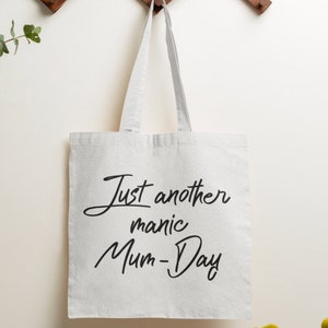 May include: White canvas tote bag with black text that reads "Just another manic Mum-Day".