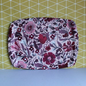 May include: A pink and purple floral patterned serving tray with a slightly rounded rectangular shape.