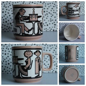 May include: A pink ceramic mug with a black and white illustration of two people and a cake. The text "The World's Best Daughter" is printed on the mug.