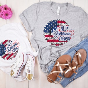 Puede incluir: Dos camisetas con un dise&ntilde;o de girasol con una bandera estadounidense y el texto "All American Girl" y "All American Mama".