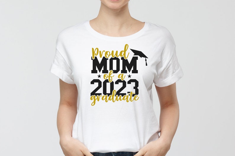 May include: White t-shirt with black text that reads "Proud Mom of a 2023 graduate" with a gold graduation cap graphic.
