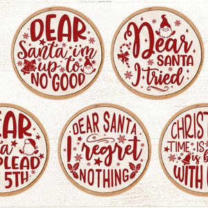 May include: Six round wooden signs with red text and white backgrounds. The signs feature Christmas-themed sayings, including "Dear Santa I'm up to no good", "Dear Santa I tried", "Dear Santa I plead the 5th", "Dear Santa I regret nothing", "Christmas time is better with wine".