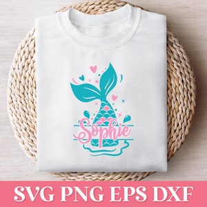 May include: A white t-shirt with a teal mermaid tail and pink hearts. The name "Sophie" is written in pink cursive lettering.