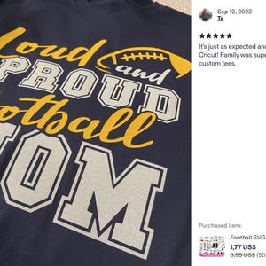 May include: A dark navy blue t-shirt featuring the yellow and silver glitter text "Loud and Proud Football Mom" with a yellow football graphic. The design uses a mix of script and block lettering, with the word "MOM" in large silver block letters.