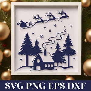 Puede incluir: Una obra de arte enmarcada con temática navideña que presenta una silueta del trineo de Papá Noel tirado por renos sobre una casa y árboles. La obra de arte está en un marco blanco, con un diseño azul oscuro. Rodeado de adornos dorados y vegetación.