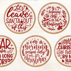 May include: Six round wooden signs with red text and Christmas-themed sayings. The signs read "Let's leave Santa out of this", "It's beginning to cost a lot like Christmas", "Dear Santa it's a long story", "I'm a morning person only on Christmas", "Home for Christmas in therapy by New Year's".