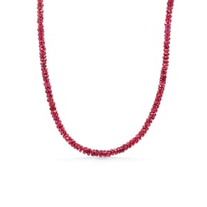 May include: A necklace composed of numerous small, faceted, deep red gemstone beads strung together in a single continuous strand. The beads are uniform in size and shape, creating a consistent texture and a vibrant, saturated crimson color throughout.