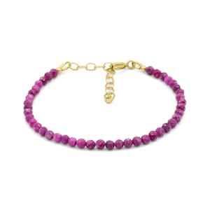 Peut inclure: Un bracelet délicat composé de petites perles de pierres précieuses facettées rose magenta vif, enfilées sur une fine chaîne dorée. Le bijou comprend un fermoir mousqueton doré et une chaînette d'extension avec un petit pendentif en forme de cœur.