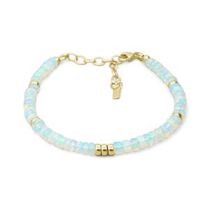 May include: A bracelet featuring a series of small, translucent, iridescent opal beads interspersed with polished gold-toned metal spacers. The design includes a gold-toned chain extender with a small rectangular metal tag at the end.