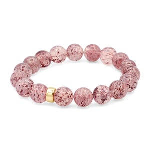 Peut inclure: Bracelet de perles roses translucides avec des inclusions rouge foncé. Les perles rondes et uniformes sont reliées par un élastique. Un élément doré sépare les perles. Chaque perle mesure environ 1 cm de diamètre.