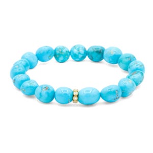 May include: A stretch bracelet composed of smooth, rounded turquoise beads in varying shades of bright blue with natural veining. A single gold-toned cylindrical spacer bead featuring three small, clear, round-cut inset stones sits at the center.