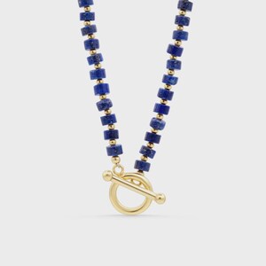 May include: A necklace featuring a repeating pattern of cylindrical deep blue lapis lazuli beads and small gold-toned spherical spacers. The piece is finished with a gold-toned toggle clasp consisting of a circular ring and a horizontal bar.