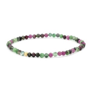 May include: A beaded bracelet featuring small, faceted, multi-colored gemstone beads in shades of deep pink, dark green, and black. The circular strand includes a single, small, textured gold-toned metal bead accent positioned near the left side.