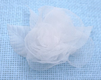 Broche de flor de gasa blanca.