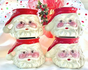 Puede incluir: Conjunto de cuatro tazas vintage de Papá Noel. Cada taza es blanca con un gorro de Papá Noel rojo y una barba blanca. Las tazas son de cerámica y tienen un acabado brillante.