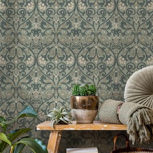 May include: A detailed shot of a wallpaper with a repeating floral pattern in shades of green, gray, and beige. A wooden shelf displays a potted cactus, a small plant, a decorative pillow, and a woven basket, creating a cozy, natural aesthetic.