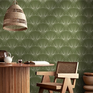 K&ouml;nnte beinhalten: Eine gr&uuml;n-wei&szlig;e geometrische Tapete mit einem f&auml;cherf&ouml;rmigen Muster. Vor der Tapete steht ein Holztisch mit einem geflochtenen Stuhl und einem geflochtenen Lampenschirm.
