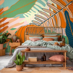 May include: A bedroom scene featuring a bed with a woven headboard and a wooden bench at the foot. The bed is adorned with pillows and a light green blanket. The wall is decorated with a large, colorful botanical mural in orange, green, and blue.