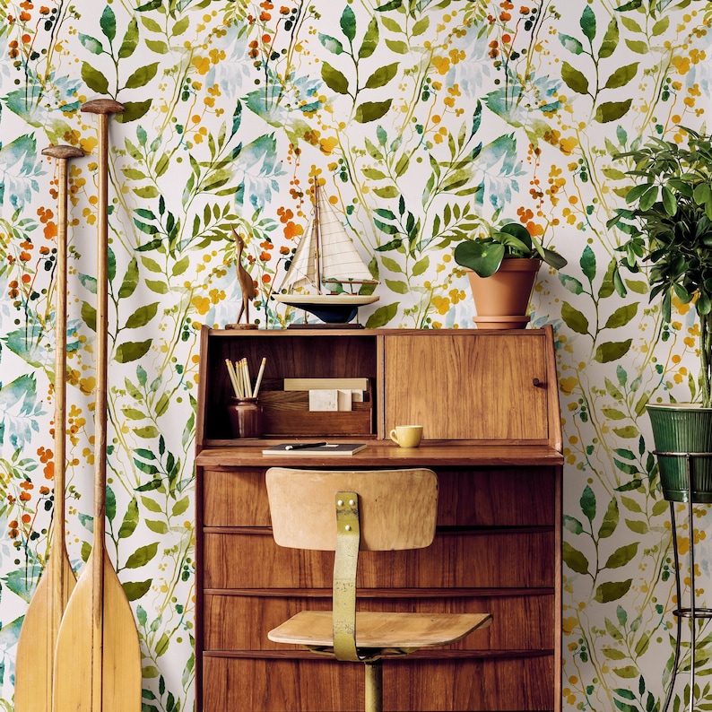 May include: A wooden desk with four drawers and a top shelf. The desk has a light wood finish and is decorated with a floral wallpaper. There are two wooden paddles leaning against the desk, a small sailboat on the shelf, and a potted plant on the desk.