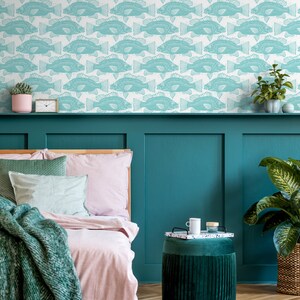 May include: A teal blue bedroom with a bed, a side table, and a plant. The walls are covered in a wallpaper with a repeating pattern of teal blue fish.