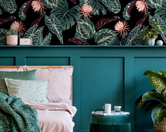 May include: A teal green headboard with a pink and green floral wallpaper behind it. A bed with a pink duvet and green throw blanket is in front of the headboard. A green velvet ottoman with a tray and a white mug on top is in the foreground.