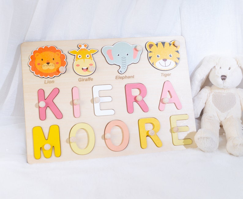 May include: Wooden name puzzle with colorful letters spelling "KIERA MOORE" and animal illustrations of a lion, giraffe, elephant, and tiger.