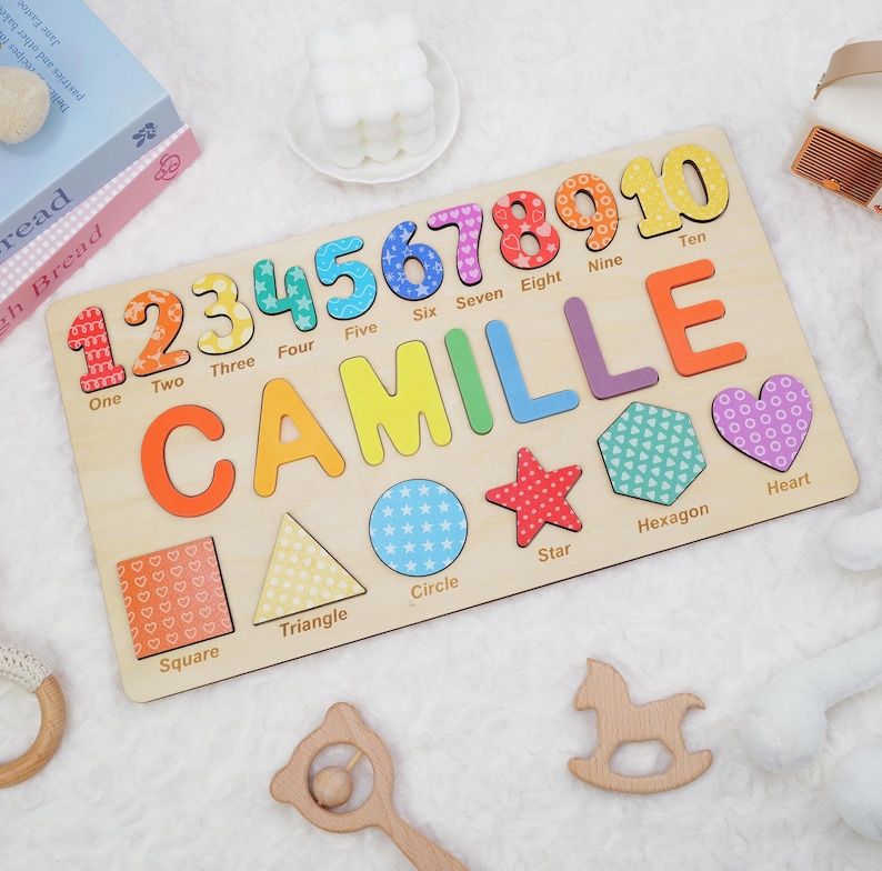 May include: A wooden puzzle with colorful numbers 1 through 10, the name Camille, and various shapes including a square, triangle, circle, star, hexagon, and heart. Each piece has a different pattern.