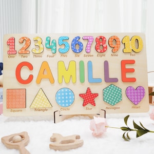 A wooden puzzle board with colorful numbers 1 through 10, the namespelled out in colorful letters, and six different shapes: a square, triangle, circle, star, hexagon, and heart. Each number, letter, and shape has a different colorful pattern.