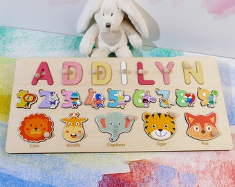 May include: A wooden puzzle board with the name "ADDILYN" spelled out in colorful letters. The board also features numbers 1 through 9 and animal illustrations, including a lion, giraffe, elephant, tiger, and fox.