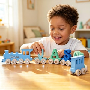 May include: A wooden toy train set featuring a light blue engine with the name Jason engraved on the side, followed by individual train cars carrying the letters J, A, S, O, and N in various shades of blue and green, all with small wheels.
