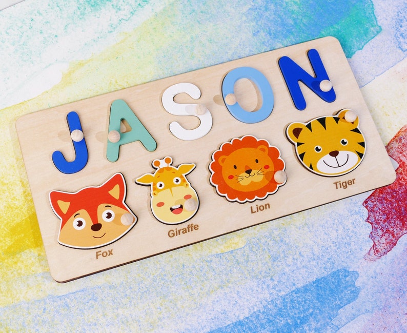 May include: A wooden puzzle board with the name "JASON" spelled out in colorful letters. The board also features animal illustrations of a fox, giraffe, lion, and tiger.
