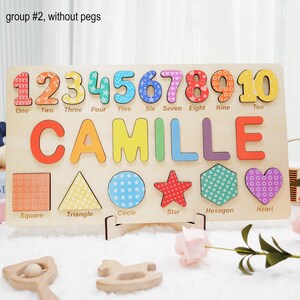 May include: A wooden puzzle with colorful numbers, letters, and shapes. The puzzle features the name "Camille" and the numbers 1 through 10. The shapes include a square, triangle, circle, star, hexagon, and heart.