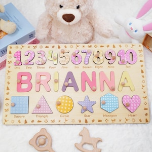 Könnte beinhalten: Ein personalisiertes Holzpuzzle mit dem Namen "BRIANNA" in bunten Buchstaben, sowie den Zahlen 1 bis 10 und verschiedenen Formen. Das Puzzle ist für Kinder konzipiert, um Zahlen, Formen und ihren Namen zu lernen.