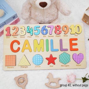 May include: A wooden puzzle with colorful numbers 1 through 10, the name Camille, and various shapes including a square, triangle, circle, star, hexagon, and heart. The puzzle is made of wood and has a light brown finish.