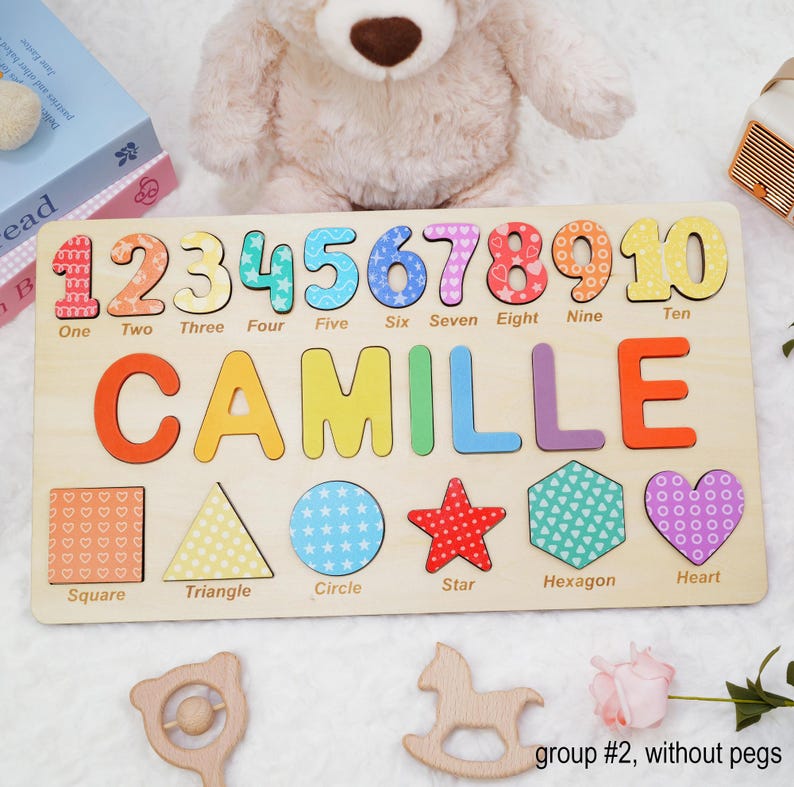 May include: A wooden puzzle with colorful numbers 1 through 10, the name Camille, and various shapes including a square, triangle, circle, star, hexagon, and heart. The puzzle is made of wood and has a light brown finish.
