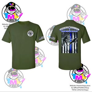 May include: Olive green t-shirt featuring a Redondo Beach Police Canine design. The front has a badge and American flag on the sleeve. The back displays a graphic of a police officer and dog with the text "PATROL NARCOTICS EXPLOSIVES".