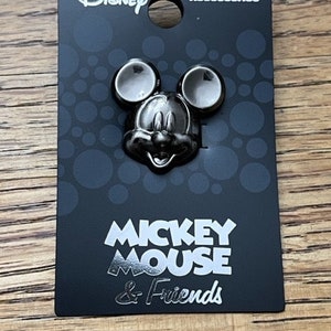 Könnte beinhalten: Eine schwarz-weiße Mickey Mouse-Anstecknadel auf einer schwarzen Karte mit weißem Text, der "Disney Pewter Accessories Mickey Mouse & Friends" lautet.