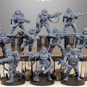 Könnte beinhalten: Eine Sammlung grauer Miniaturfiguren futuristischer Soldaten, jede mit verschiedenen Waffen bewaffnet. Die Figuren sind in dynamischen Posen dargestellt, die Action und Kampf suggerieren. Das detaillierte Design umfasst Helme, Rüstungen und Ausrüstung.