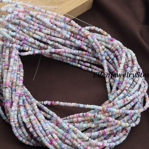 May include: Strands of colorful, small, flat beads in pastel shades of pink, blue, purple, and cream. The beads are strung together, creating a textured and layered effect. The image is of a jewelry supply, perfect for crafting necklaces and bracelets.
