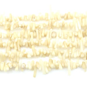 May include: A strand of off-white coral beads. The beads are irregular in shape and have a natural, organic look.