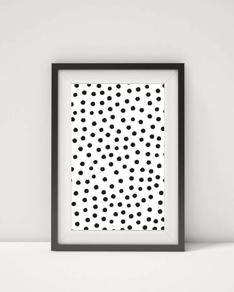May include: Framed art print featuring a white background with a pattern of evenly spaced black dots. The print is encased in a black frame with a white mat, creating a modern, minimalist aesthetic. The artwork is suitable for various interior design styles.